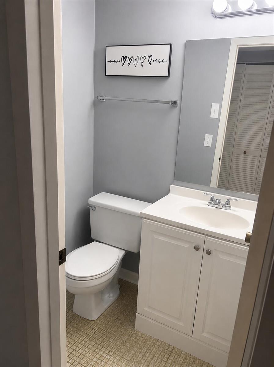 A small bathroom features a white vanity, a toilet, and a wall-mounted heart art piece — 2013 Lincoln A, Boca Raton FL 33434, BOCA RATON, FL