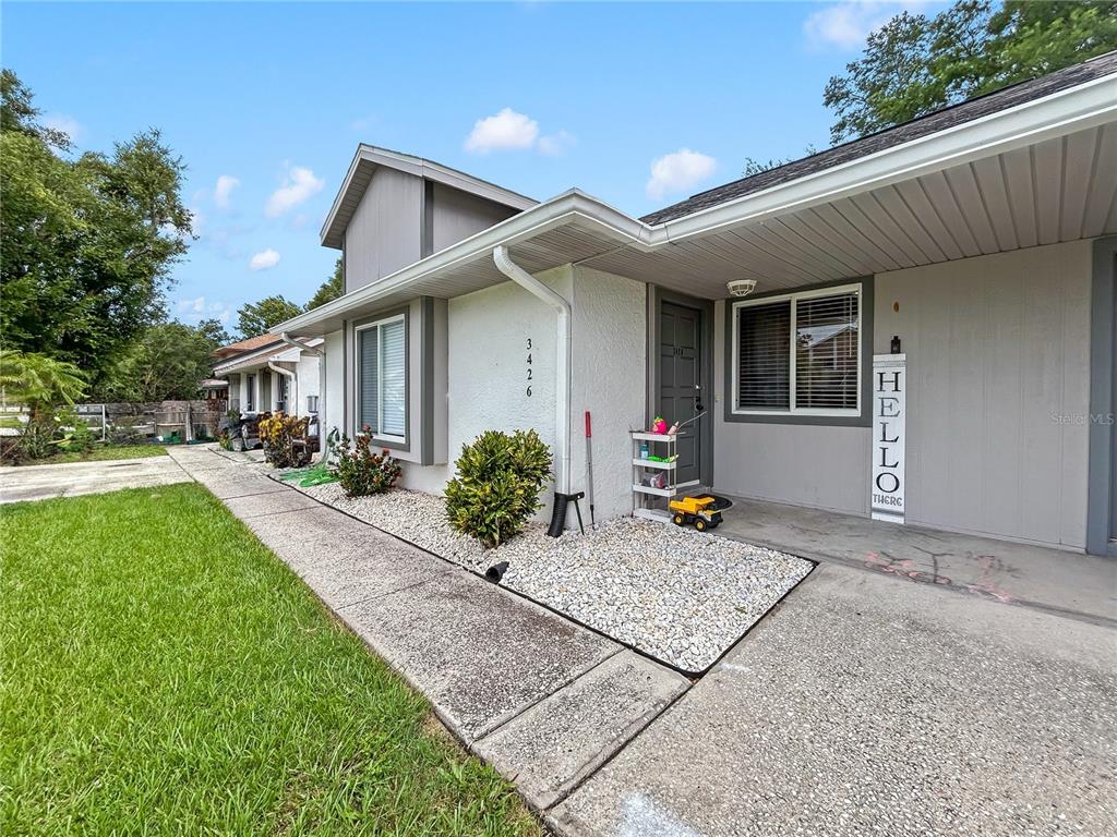 A single-story house exterior features a white stucco facade, a gravel garden, and a concrete walkway — 3426 LAUREL DALE DRIVE, TAMPA, FL