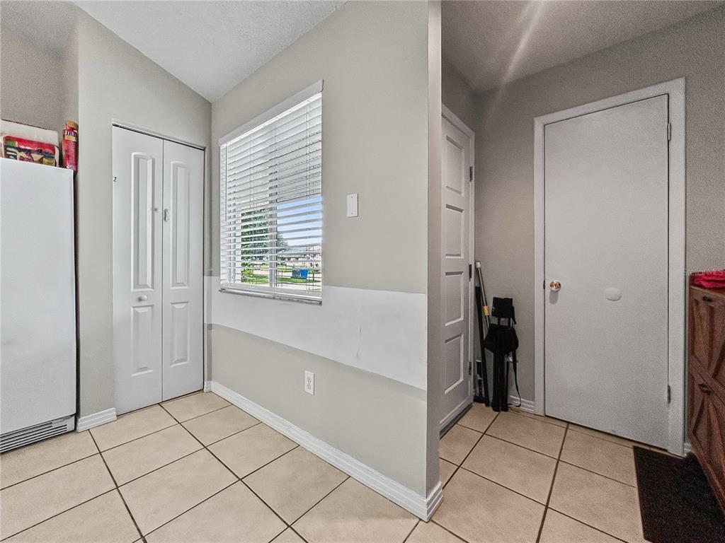 A tiled laundry room features a window, two white doors, and a partial wall — 3426 LAUREL DALE DRIVE, TAMPA, FL