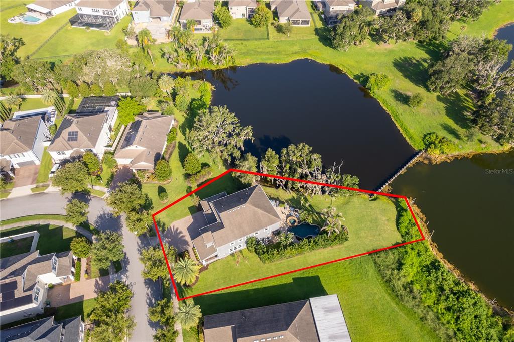 An aerial view shows a house with a pool and large yard beside a lake — 15838 CITRUS GROVE LOOP, WINTER GARDEN, FL