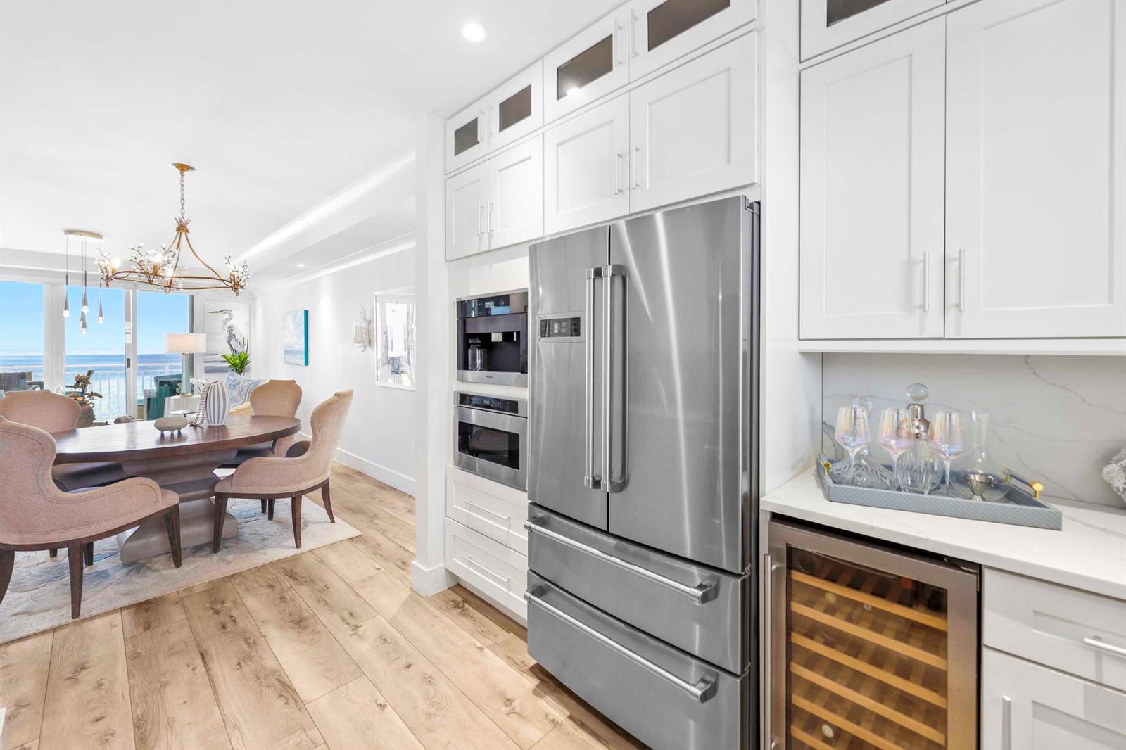 A kitchen with white cabinets, stainless steel appliances, and a view of the dining area — 2921 S Ocean Boulevard # 704, Highland Beach FL 33487, HIGHLAND BEACH, FL