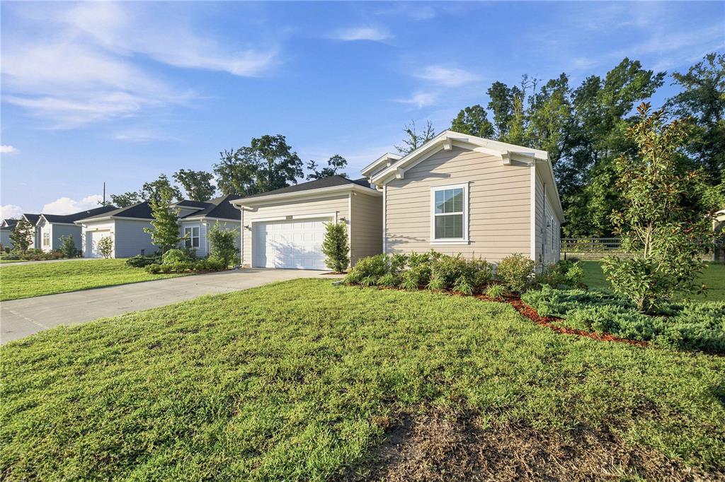 A light-colored, single-story suburban house with a garage and a large front lawn — 3492 NE 38TH LANE, OCALA, FL