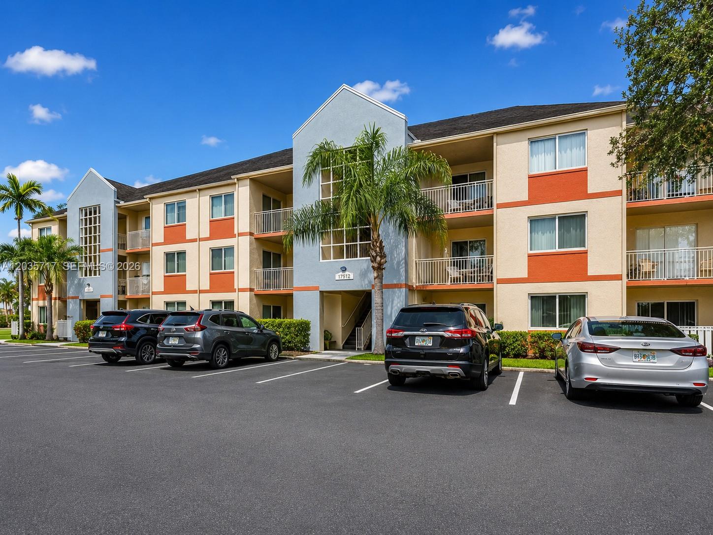 A multi-story apartment building with a parking lot in front and palm trees — 18840 NW 57th Ave # 302, Hialeah FL 33015, HIALEAH, FL