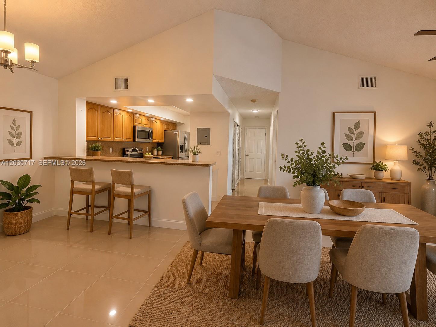 A dining area with a wooden table and chairs sits adjacent to an open kitchen — 18840 NW 57th Ave # 302, Hialeah FL 33015, HIALEAH, FL