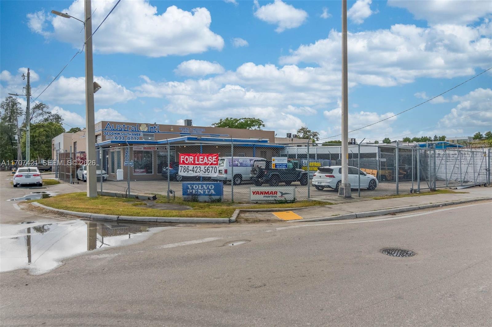 A commercial building with a fenced lot and a for lease sign — 3200 NW South River Dr, Miami FL 33142, MIAMI, FL