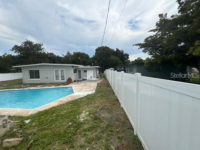 A backyard features a swimming pool, a white vinyl fence, and a single-story house — 156 PINECREST DR, SANFORD, FL