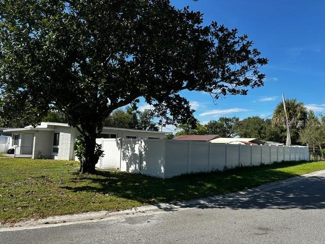A white house with a large tree and a white vinyl fence in the yard — 156 PINECREST DR, SANFORD, FL