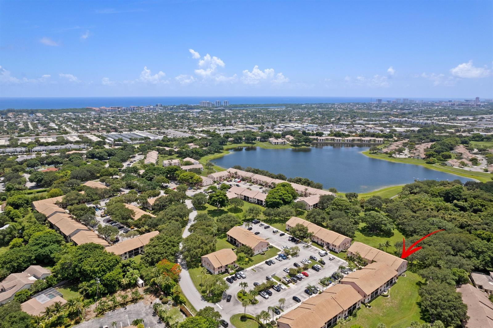 An aerial view of a residential apartment complex with a lake in the background — 3355 Jaywood Terrace # 2110, Boca Raton FL 33431, BOCA RATON, FL
