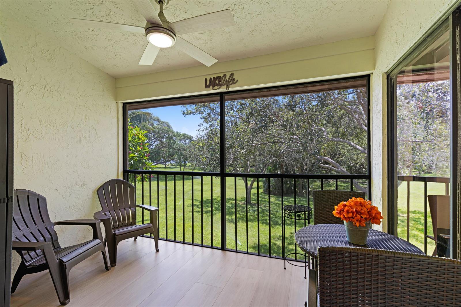 A screened-in porch features a ceiling fan, wood-look flooring, and a view of trees — 3355 Jaywood Terrace # 2110, Boca Raton FL 33431, BOCA RATON, FL