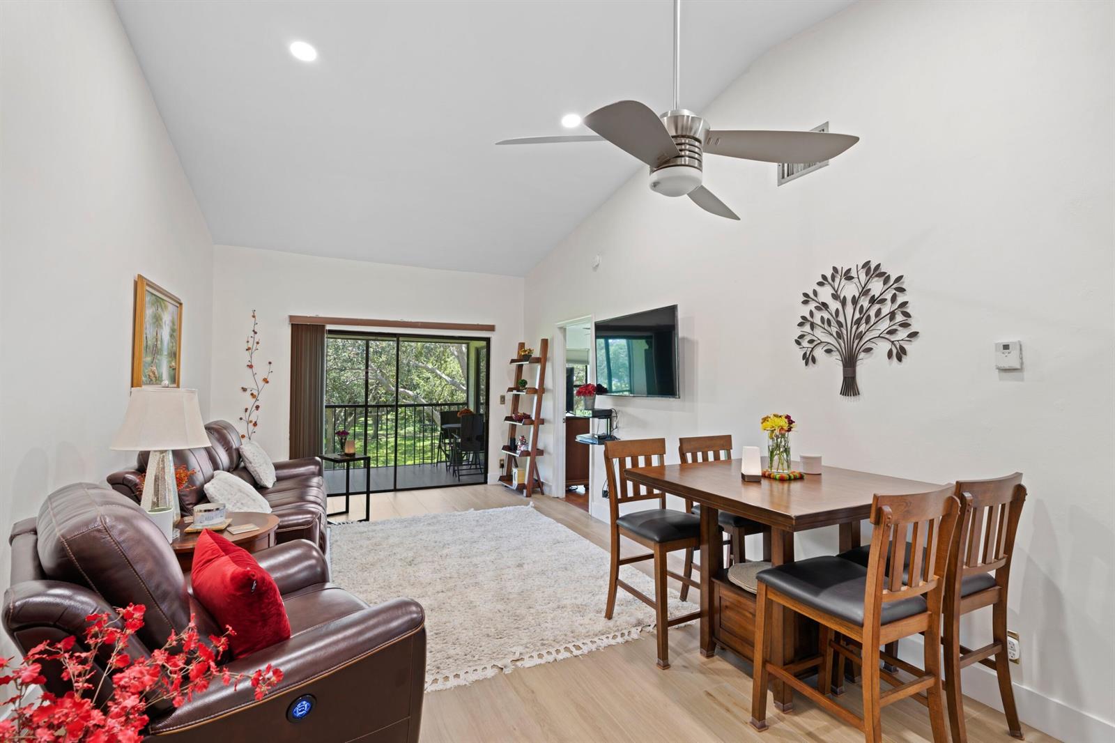 A living and dining room features leather furniture, a ceiling fan, and a sliding door — 3355 Jaywood Terrace # 2110, Boca Raton FL 33431, BOCA RATON, FL