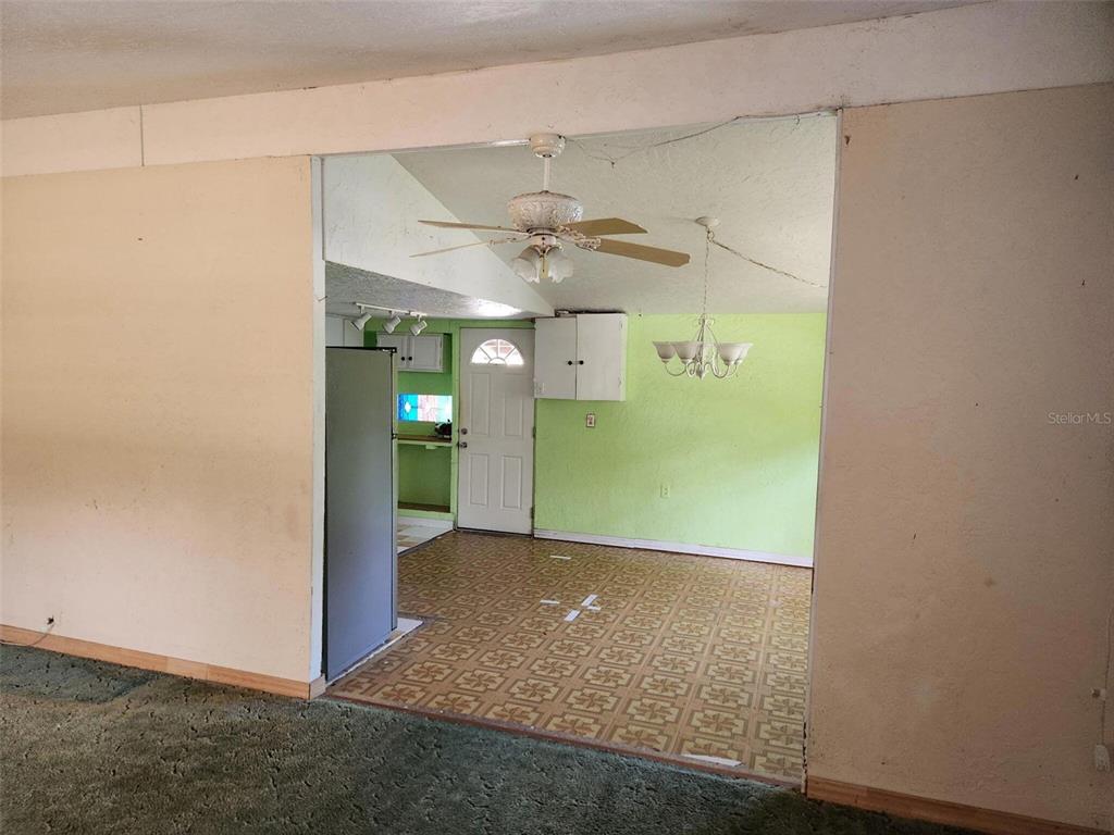 A view from a carpeted room into a kitchen and dining area with patterned flooring — 2319 S SUMMERLIN AVENUE, SANFORD, FL