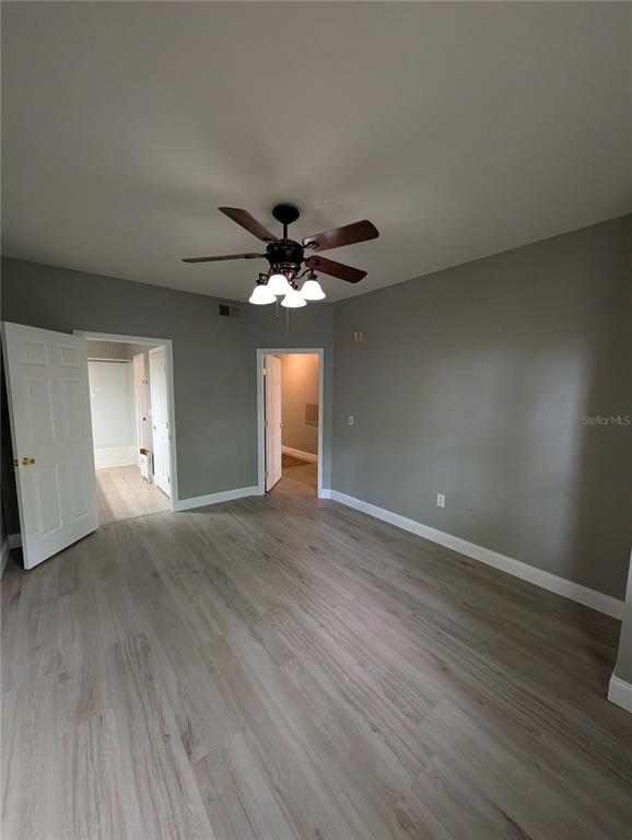 A bedroom with light wood-look flooring, gray walls, and a ceiling fan — 2632 ROBERT TRENT JONES DRIVE UNIT 110, ORLANDO, FL