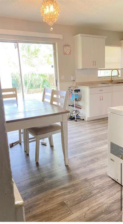 A dining area with wood-look flooring, a white table, and a sliding glass door — 2412 MARSHALL AVENUE, SANFORD, FL