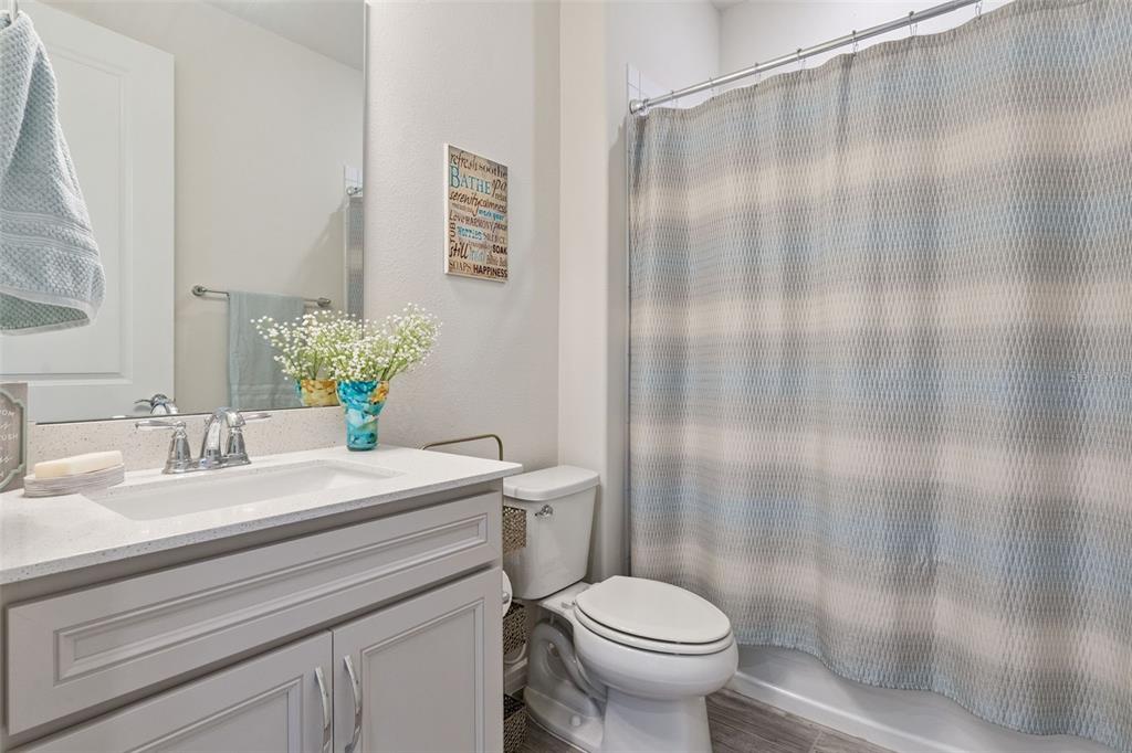 A bathroom features a gray vanity with a white countertop, a toilet, and a shower curtain — 13940 DESTIN BEACH LANE, ORLANDO, FL