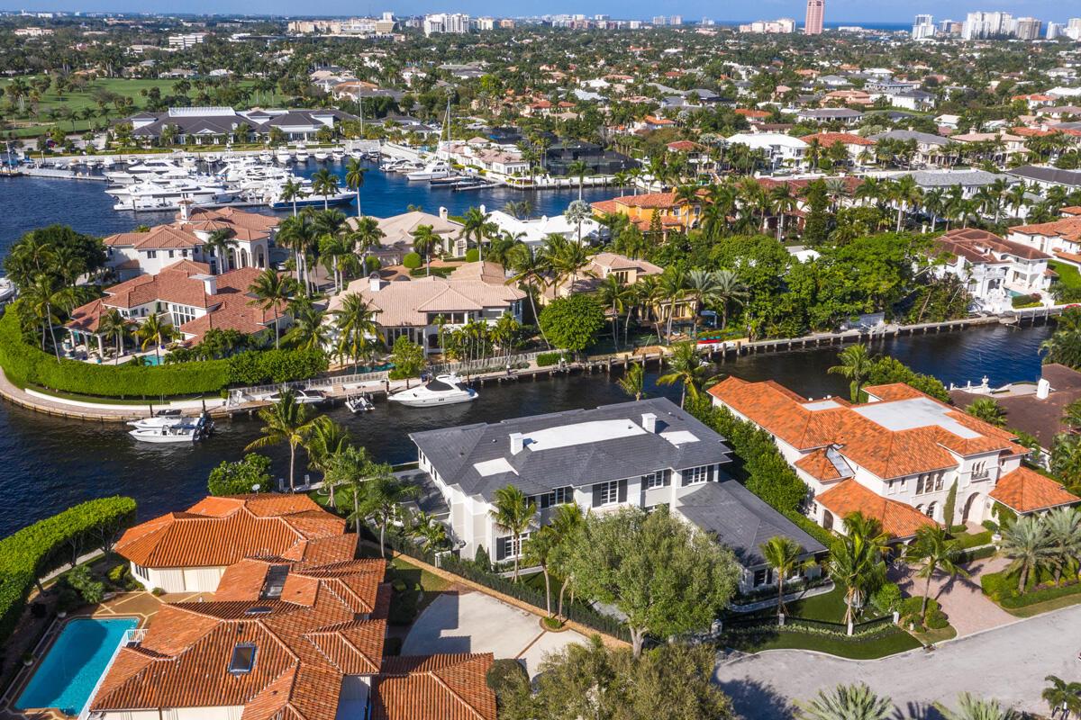 An aerial view shows luxury waterfront homes with tile roofs, private docks, and swimming pools — 133 W Coconut Palm Road, Boca Raton FL 33432, BOCA RATON, FL