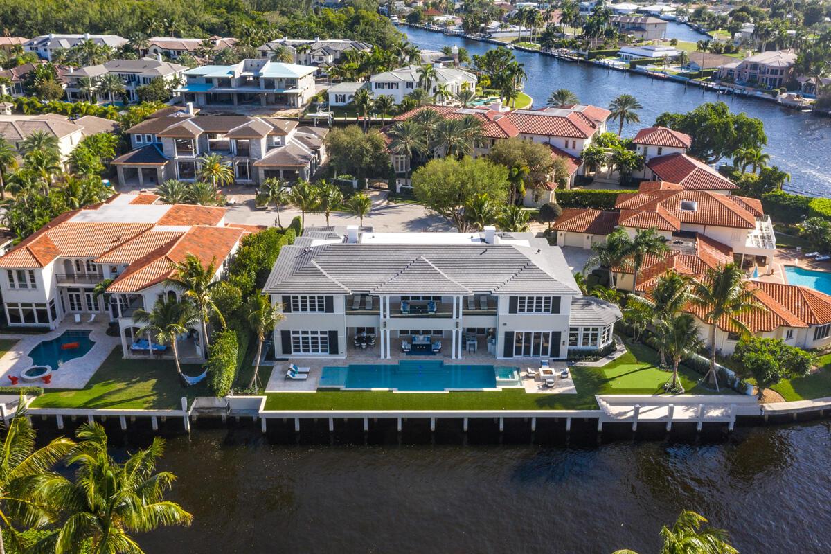An aerial view of a waterfront mansion with a swimming pool and a tiled roof — 133 W Coconut Palm Road, Boca Raton FL 33432, BOCA RATON, FL