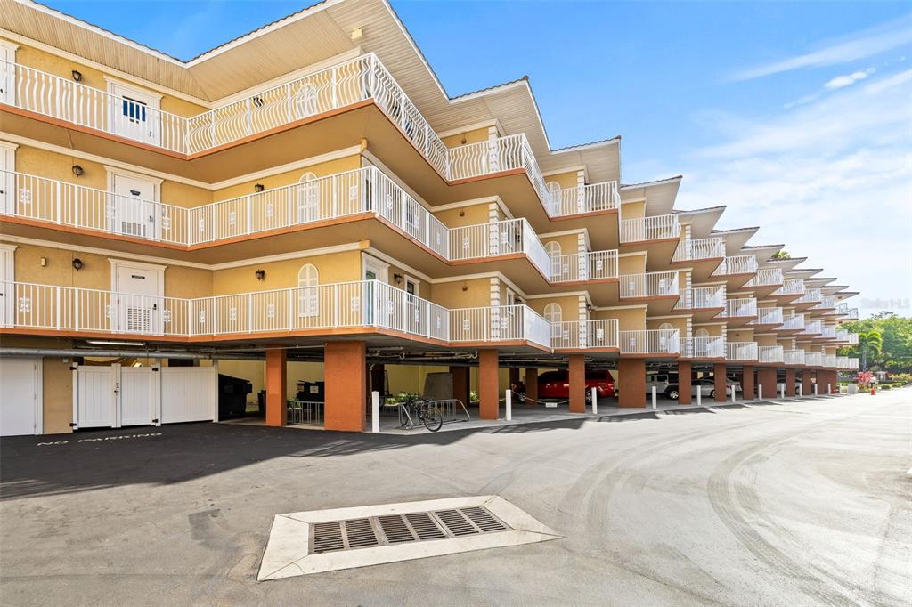 A multi-story apartment building with elevated balconies and covered parking on the ground level — 1420 BAYSHORE BOULEVARD UNIT 206, DUNEDIN, FL