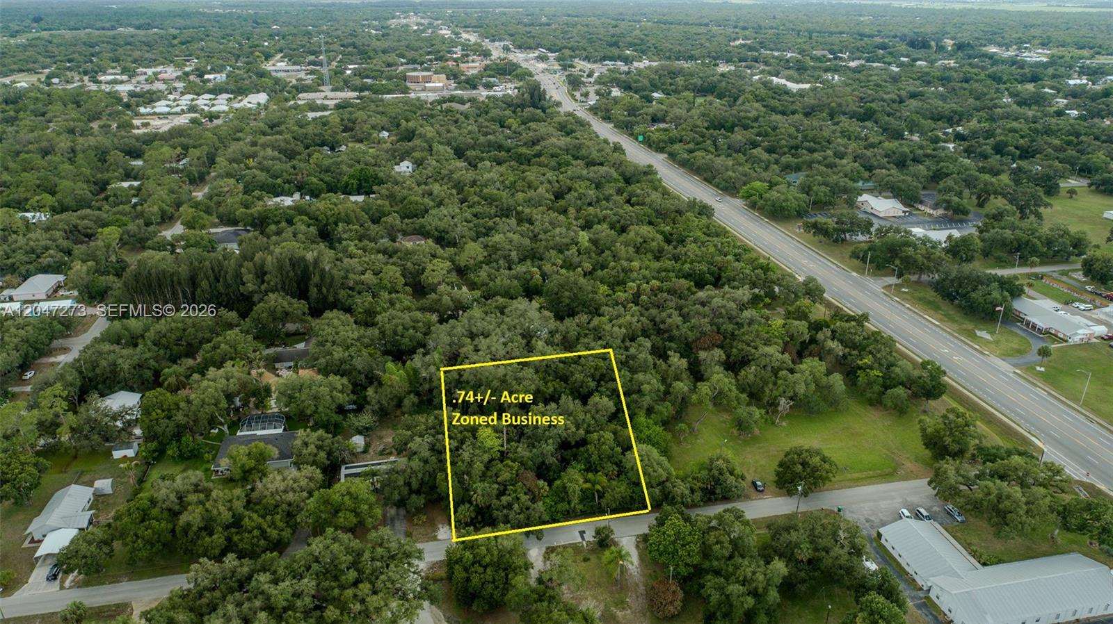 An aerial view shows a rectangular, wooded plot of land marked as .74 acres — 543 E Hickpochee Ave, La Belle FL 33935, LA BELLE, FL