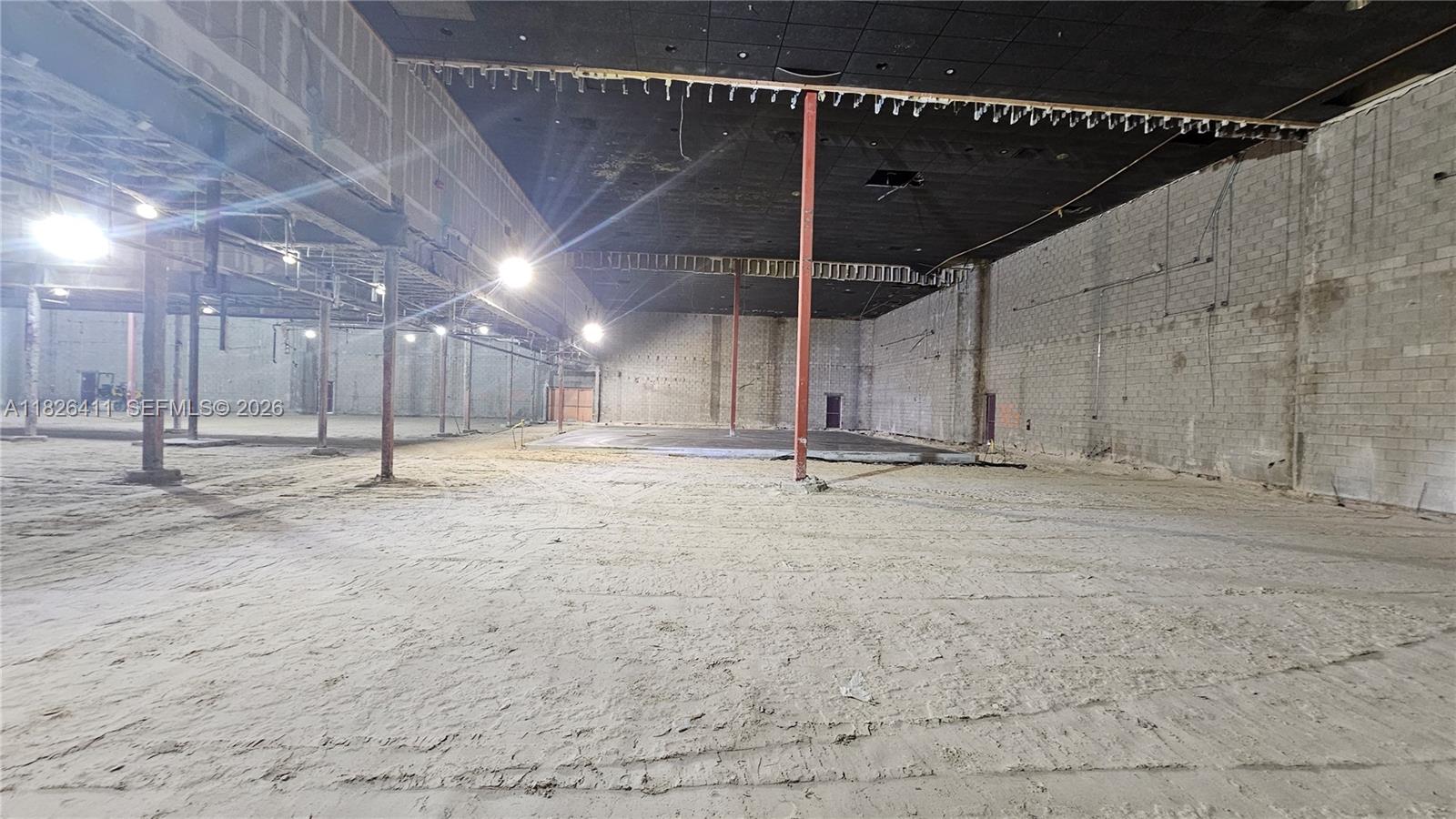 An expansive, unfinished commercial interior features exposed concrete block walls, a dark ceiling, and dirt flooring — 17355 NW 59th Ave, Hialeah FL 33015, HIALEAH, FL