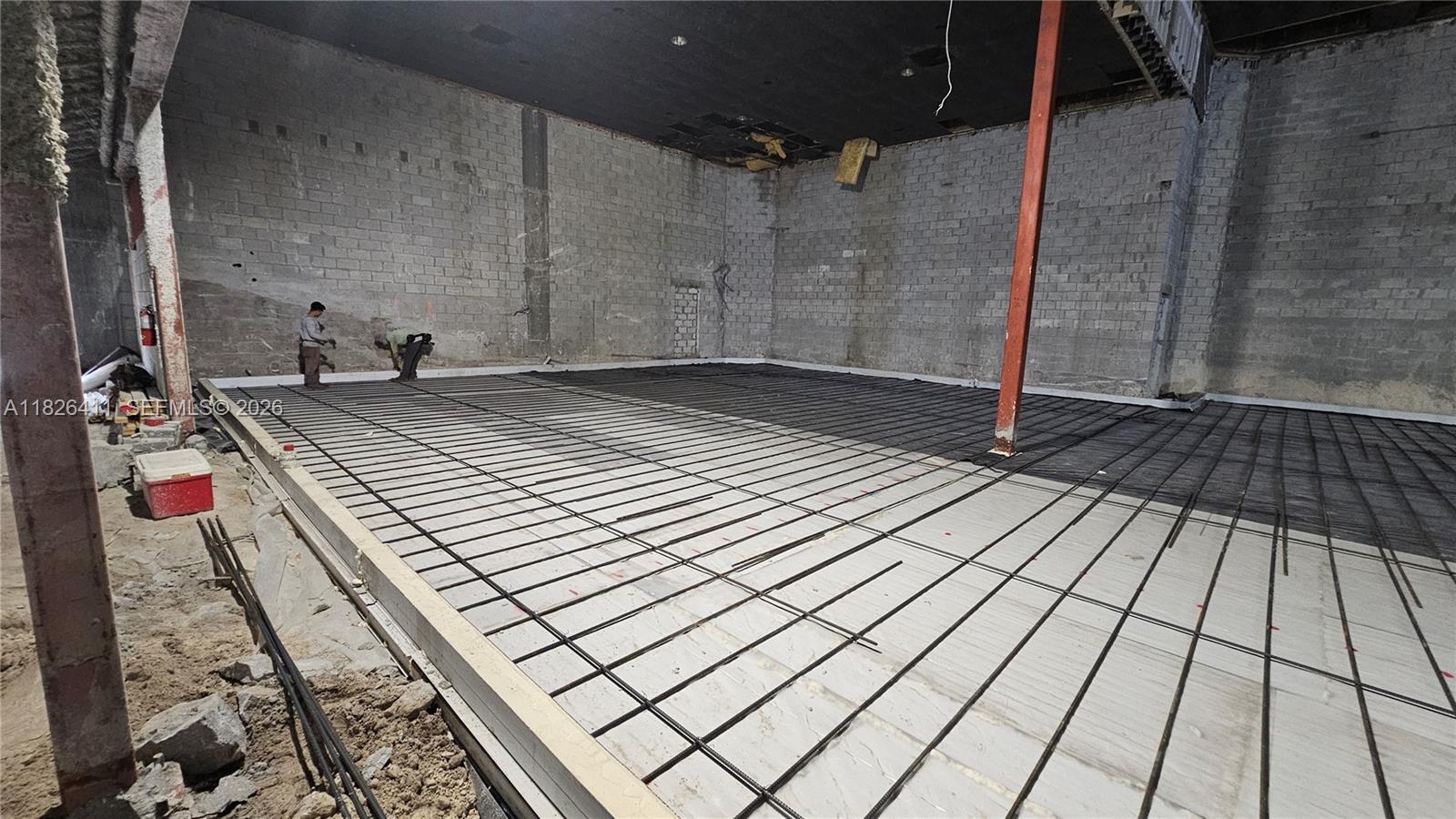 Construction workers prepare a concrete floor with rebar reinforcement inside an unfinished commercial space — 17355 NW 59th Ave, Hialeah FL 33015, HIALEAH, FL