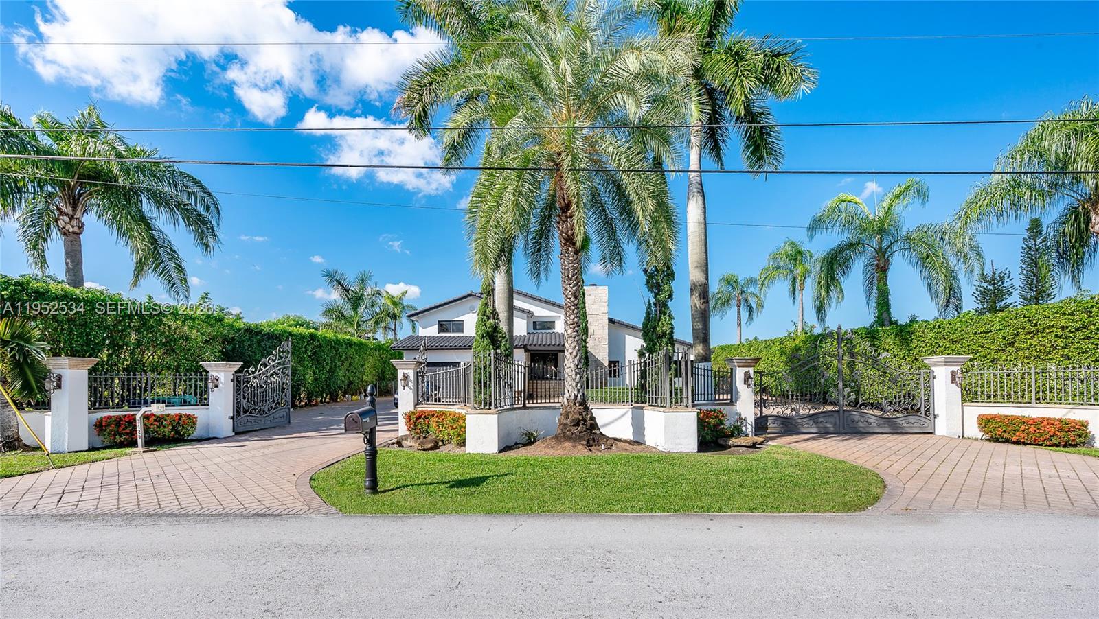 A gated driveway leads to a two-story house surrounded by palm trees and hedges — 3420 SW 129th Ave, Miami FL 33175, MIAMI, FL