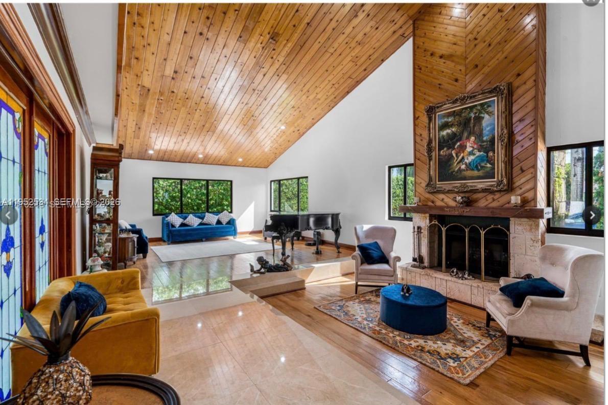 A spacious living room features a vaulted wood-paneled ceiling, a stone fireplace, and mixed flooring — 3420 SW 129th Ave, Miami FL 33175, MIAMI, FL