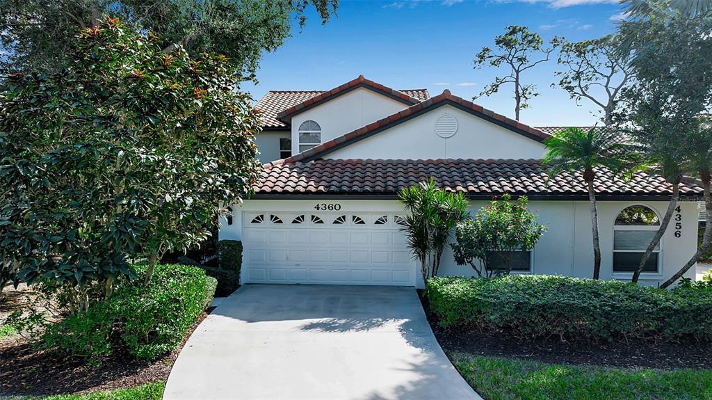 A two-story house with a white stucco facade, a tile roof, and a two-car garage — 4360 CAMINO MADERA, SARASOTA, FL