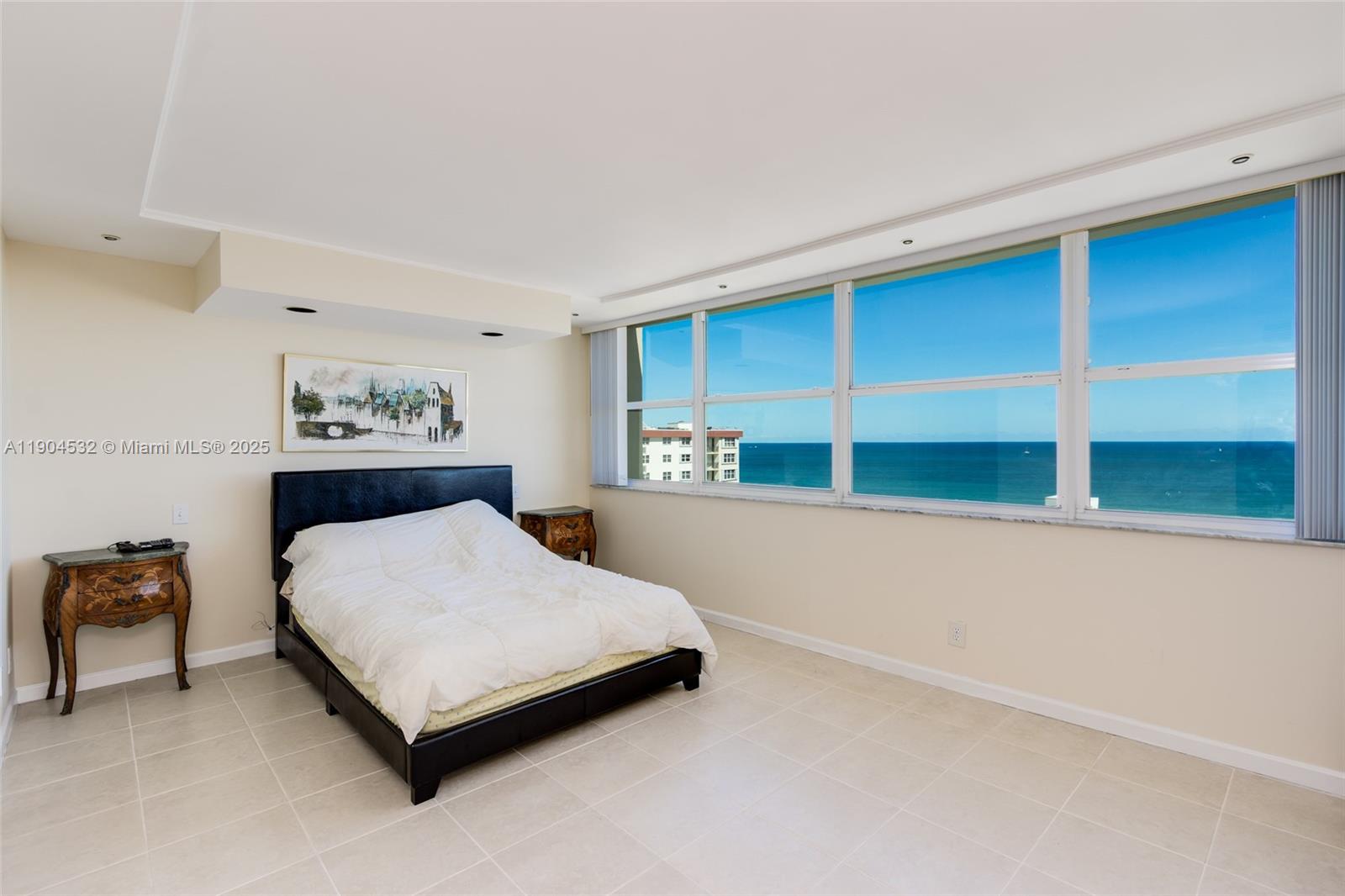 A bedroom features a black bed, two ornate side tables, and large windows overlooking the ocean — 1410 S Ocean Dr # 1702, Hollywood FL 33019, HOLLYWOOD, FL