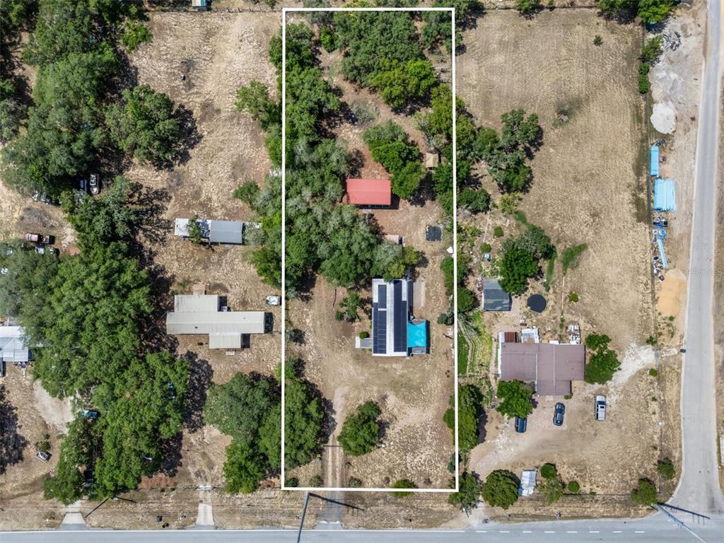 An aerial view shows a residential property lot outlined in white, featuring two buildings — 2742 MASTERPIECE ROAD, LAKE WALES, FL