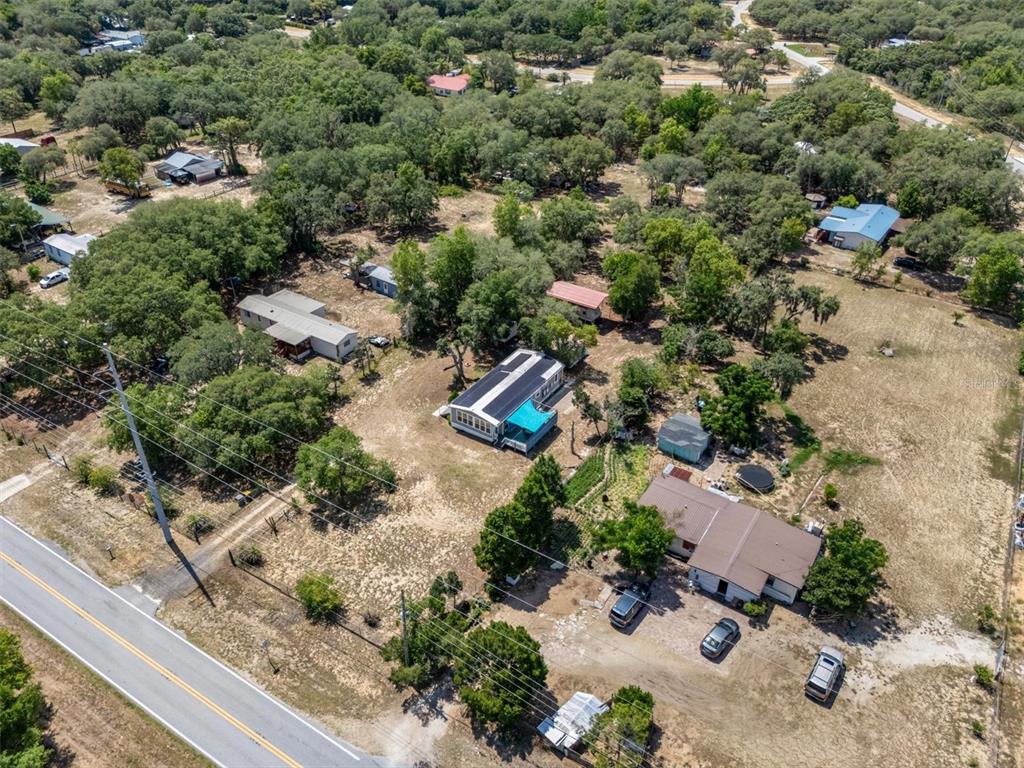 An aerial view shows several houses on a large, wooded lot near a paved road — 2742 MASTERPIECE ROAD, LAKE WALES, FL