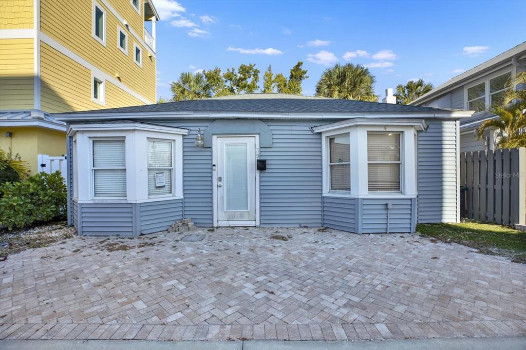 A single-story blue house with a paved front patio and two bay windows — 39 181ST AVENUE W, REDINGTON SHORES, FL