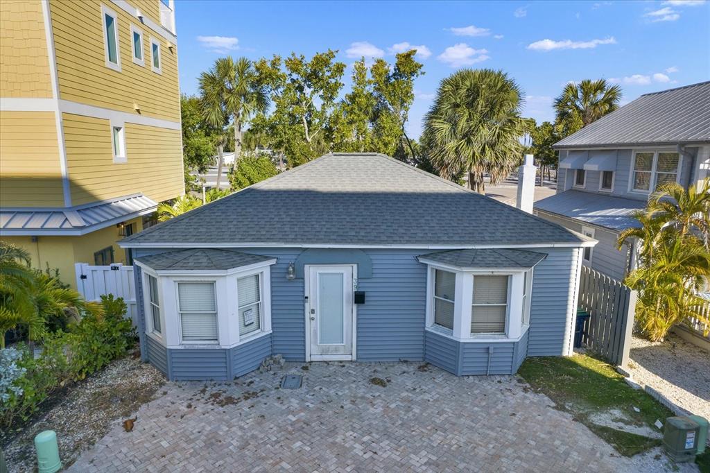A blue, single-story house with a hip roof and two bay windows faces a driveway — 39 181ST AVENUE W, REDINGTON SHORES, FL