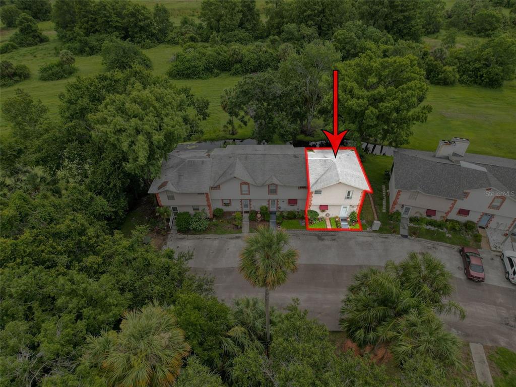 An aerial view shows a two-story townhouse unit highlighted in red within a residential complex — 7135 TRENTON PLACE, NEW PORT RICHEY, FL