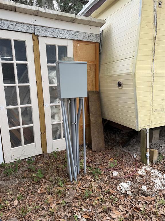 An outdoor electrical panel stands on a post next to a shed and a trailer — 11259 NE 10TH TERRACE, OXFORD, FL