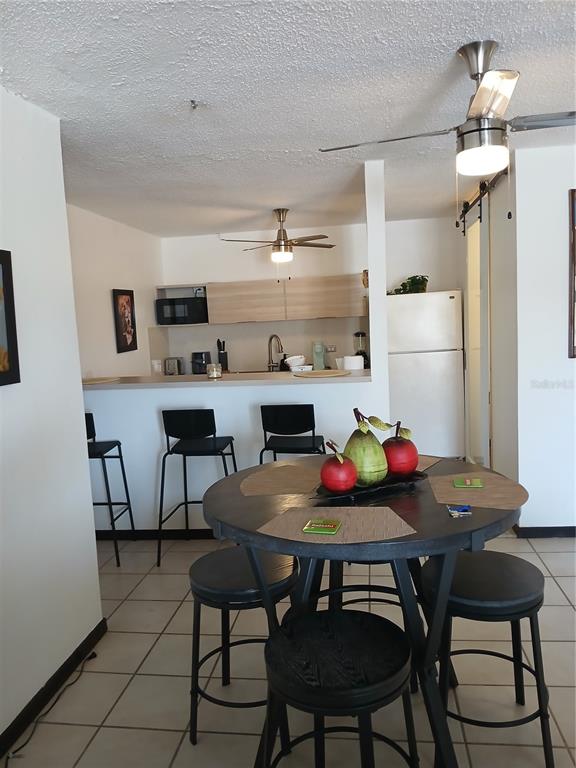 A dining area with a round table and stools sits in front of a kitchen — Villa Marina Condo VILLA MARINA AVE. UNIT G301, FAJARDO, PR