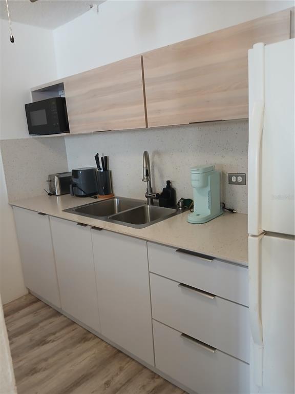 A kitchen features light wood upper cabinets, white lower cabinets, a double sink, and appliances — Villa Marina Condo VILLA MARINA AVE. UNIT G301, FAJARDO, PR
