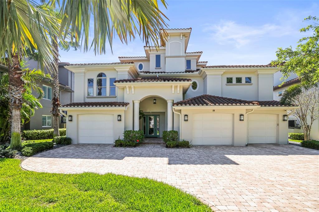 A two-story Mediterranean-style house features a three-car garage and a paved driveway — 19 BAYFRONT COURT S, ST PETERSBURG, FL