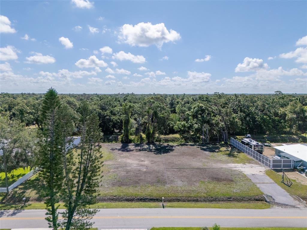 An aerial view shows a vacant, cleared rectangular lot bordering a paved road — 1941 E LEEWYNN DRIVE, SARASOTA, FL