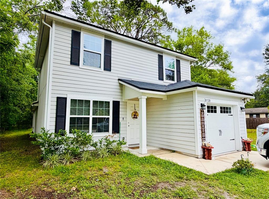 A two-story house with light-colored siding, black shutters, and an attached one-car garage — 8139 VINING STREET, JACKSONVILLE, FL