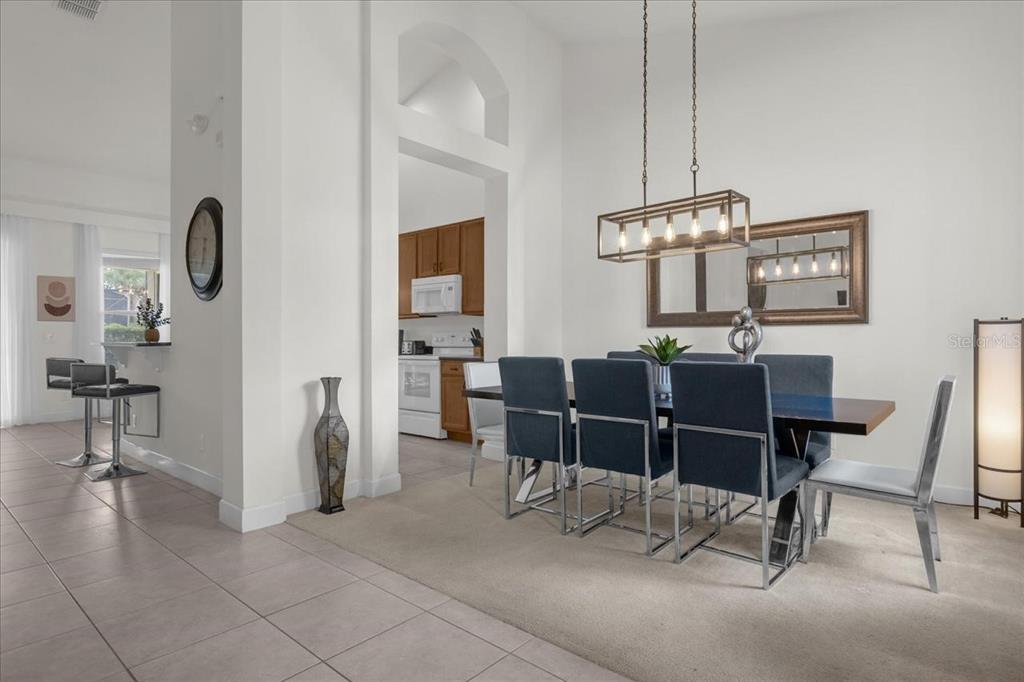 A dining room with a rectangular table, blue chairs, and a modern light fixture — 4072 OAKTREE DRIVE, DAVENPORT, FL