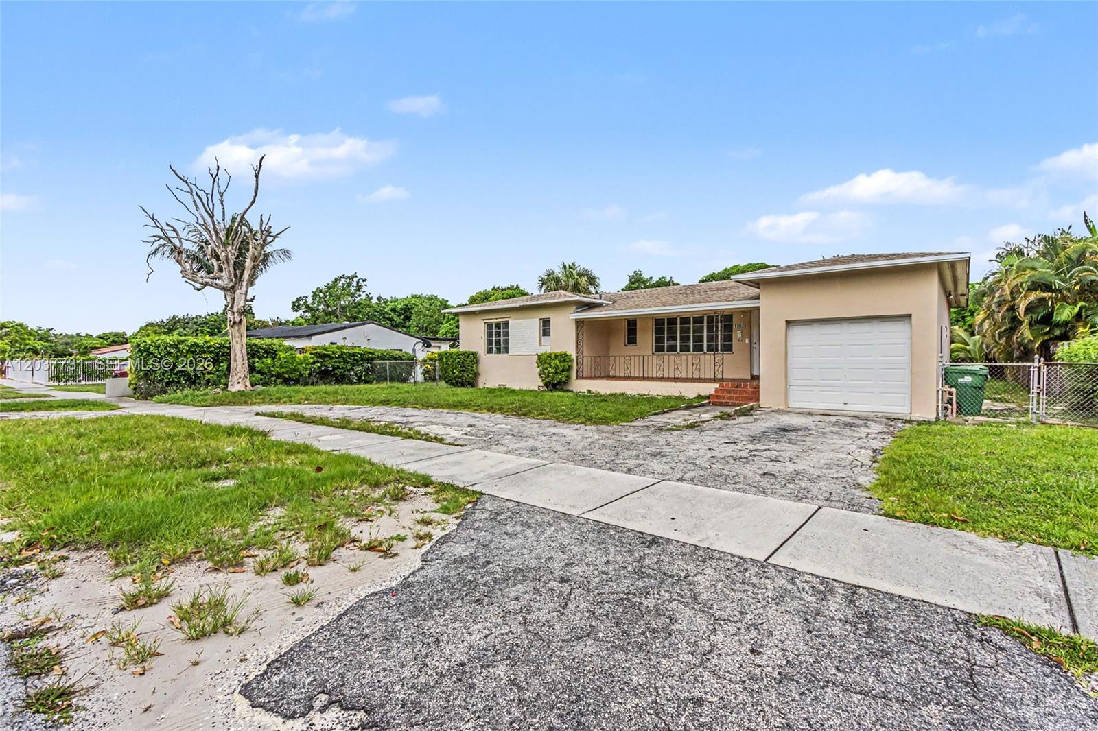 A single-story house with a beige exterior, a one-car garage, and a weathered concrete driveway — 13020 NW 1st Ave, Miami FL 33168, MIAMI, FL