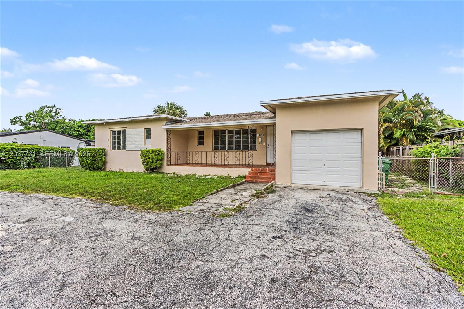 A single-story house with a beige stucco exterior, a front porch, and an attached garage — 13020 NW 1st Ave, Miami FL 33168, MIAMI, FL