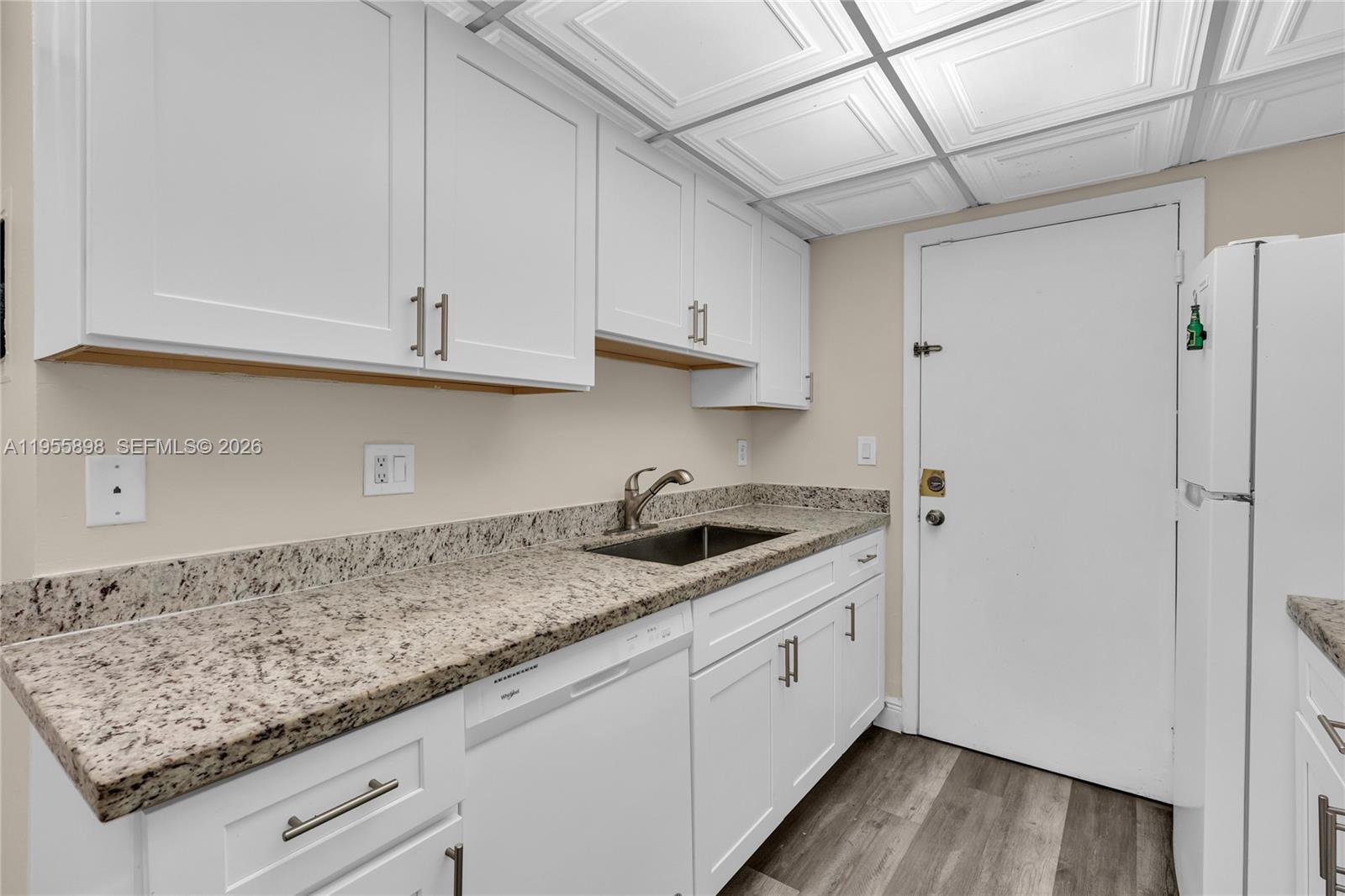A kitchen features white cabinets, granite countertops, a stainless steel sink, and a drop ceiling — 17901 NW 68th Ave # T206, Hialeah FL 33015, HIALEAH, FL