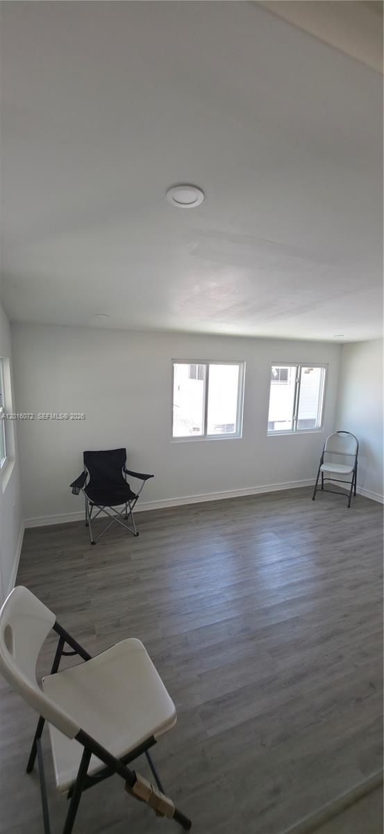 An empty room features light-colored wood-look flooring, white walls, and three folding chairs — 1730 SW 85th Ave, Davie FL 33324, DAVIE, FL