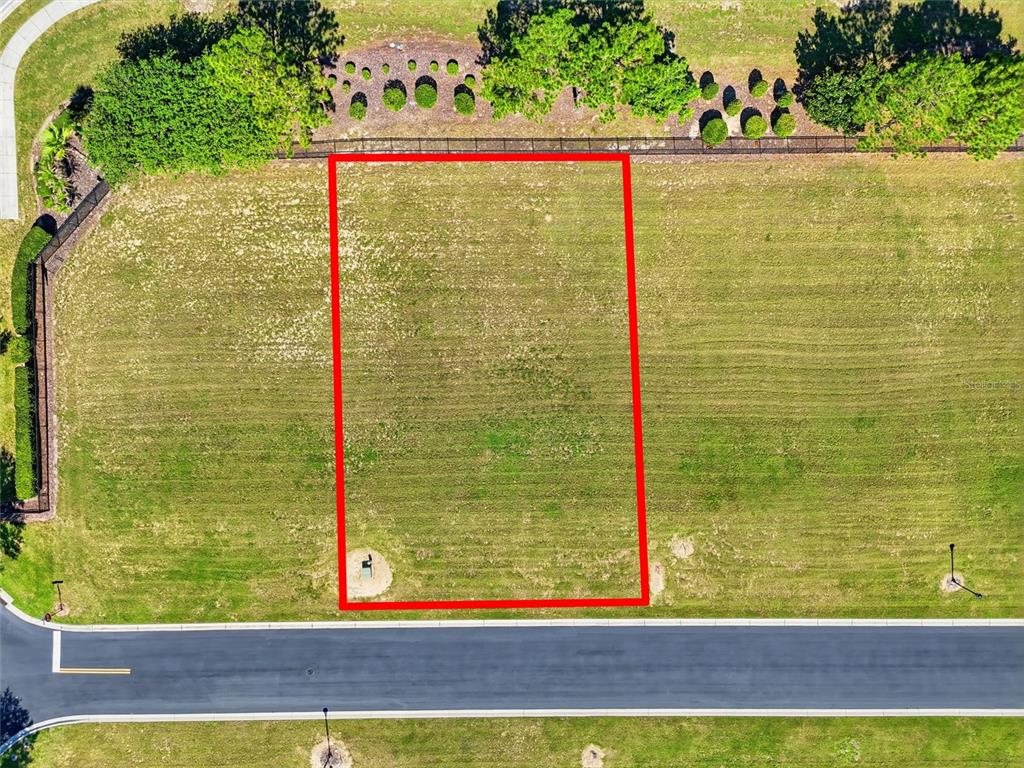 An aerial view shows a rectangular vacant residential lot outlined in red along a street — 504 BONAMIA AVENUE, LAKE ALFRED, FL
