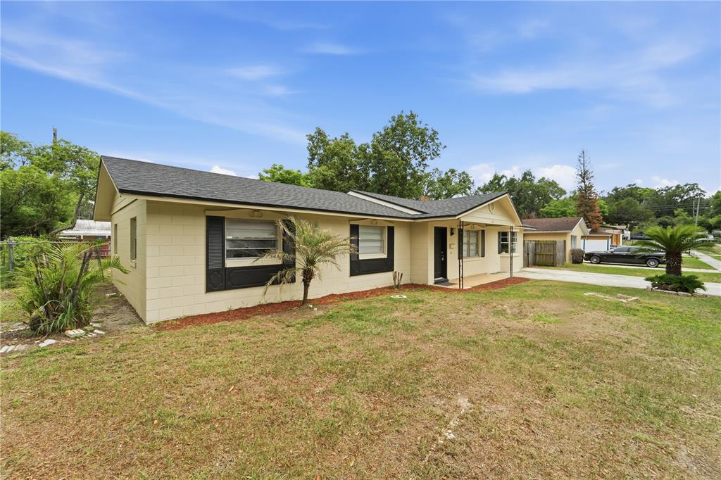 A single-story house with tan block walls, a dark roof, and black window shutters — 2213 VILLANO AVENUE, ORLANDO, FL