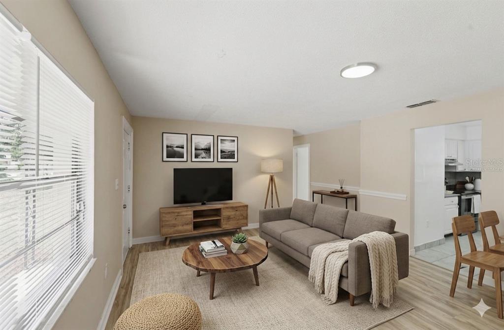 This virtually staged living room features a gray sofa, wood coffee table, and television console — 2213 VILLANO AVENUE, ORLANDO, FL