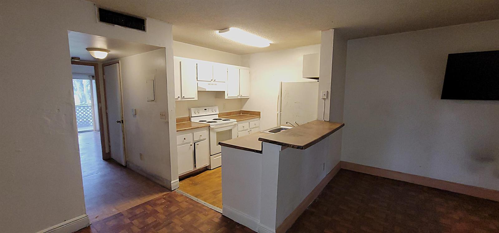 A kitchen with white cabinets, a white stove, and a breakfast bar overlooking a room — 1509 Meadows Circle W, Boynton Beach FL 33436, BOYNTON BEACH, FL