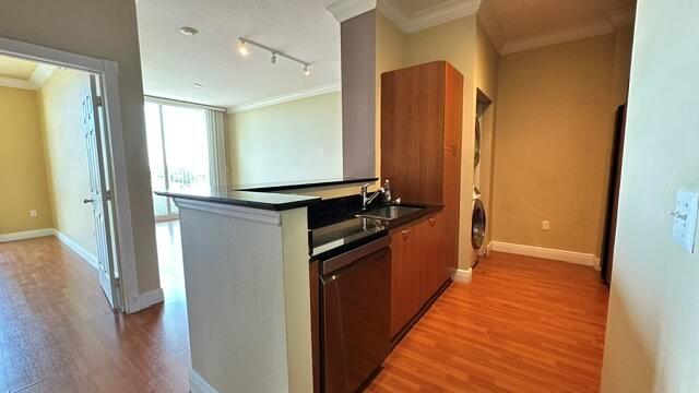 A kitchen area with dark wood cabinets, a dishwasher, and wood-look flooring — 100 NE 6th Street # 709, Boynton Beach FL 33435, BOYNTON BEACH, FL