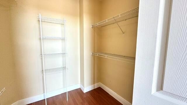 A walk-in closet with wire shelving and wood-look flooring — 100 NE 6th Street # 709, Boynton Beach FL 33435, BOYNTON BEACH, FL